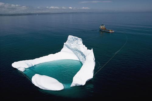 a-ship-towing-an-iceberg-off-the-coast-of-newfoundland-to-prevent-the-iceberg-from-hitting-an-offshore-drilling-platform